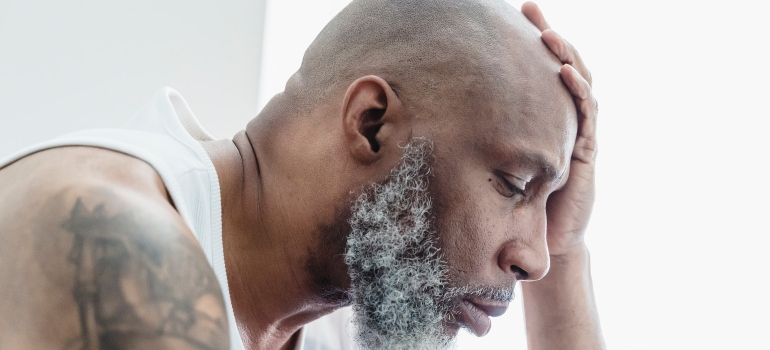 elder black man holding his head