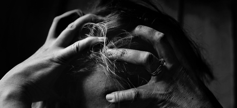 black and white phtoograph of a woman holding her head