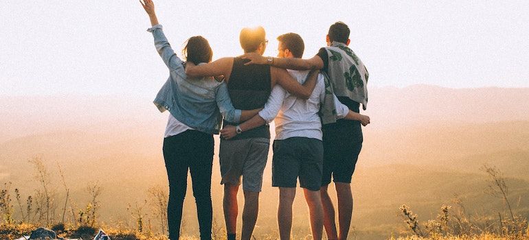 Four young people hugging.