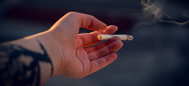 person holding a lit cigarette