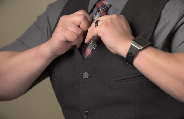 A close-up of a man fixing up his suit.