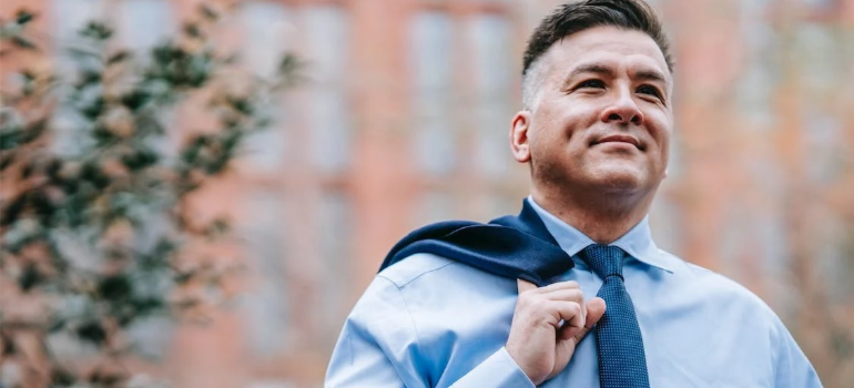 A close-up of a man in a blue shirt and necktie showing the importance of self-efficacy in addiction recovery.