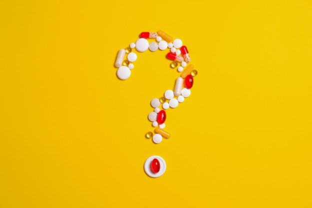 A question mark made out of drugs as a sign of learning how to tell the difference between dependence and addiction