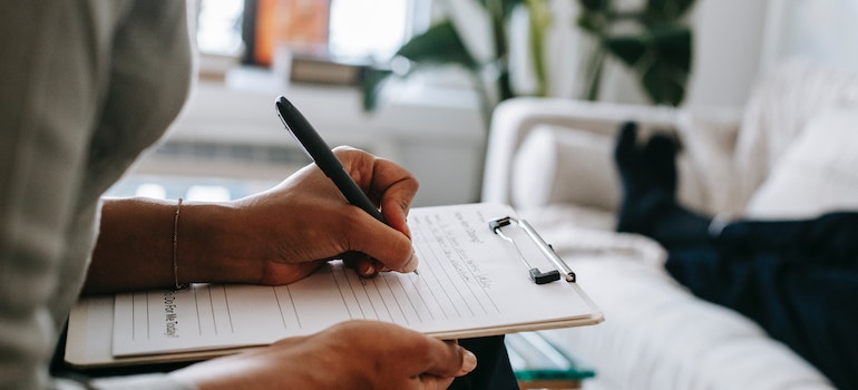 unrecognizable woman writing on a paper