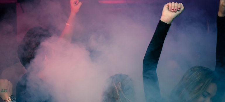 Happy people dancing with smoke around them.