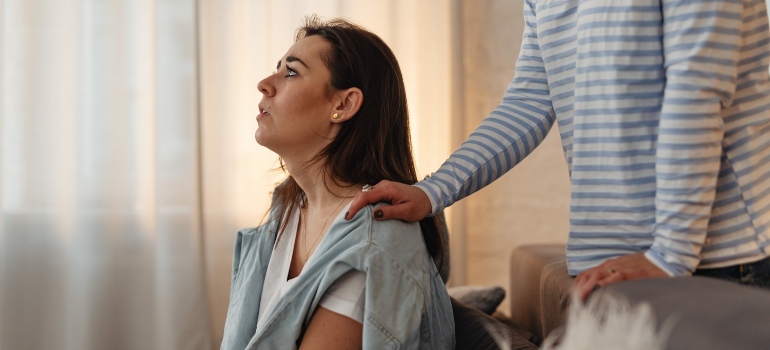 worried woman supported by a friend