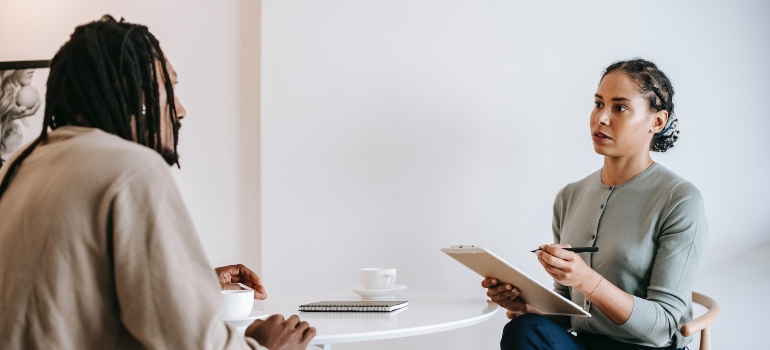 a guy talking with his therapist about traveling while in recovery