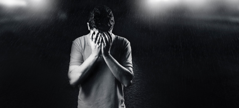 man waiting for someone while holding his face in his hands