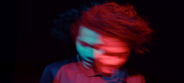 a blurry man against a black background representing the issues of dating in early recovery