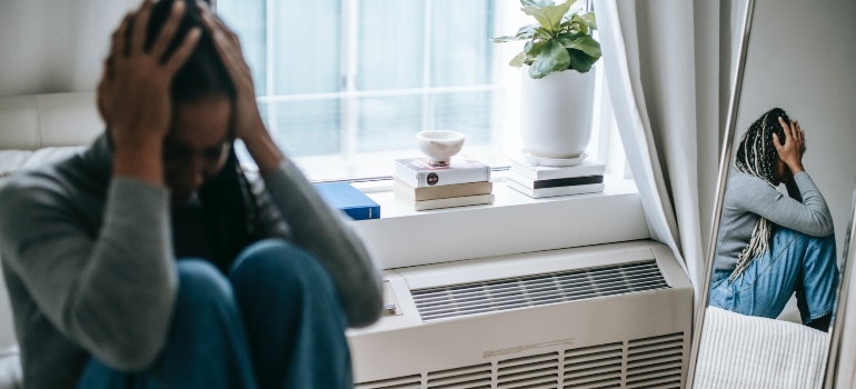 woman sitting alone in her bedroom representing problems that moms in recovery face