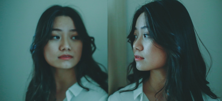 young woman looking at her reflection in a mirror