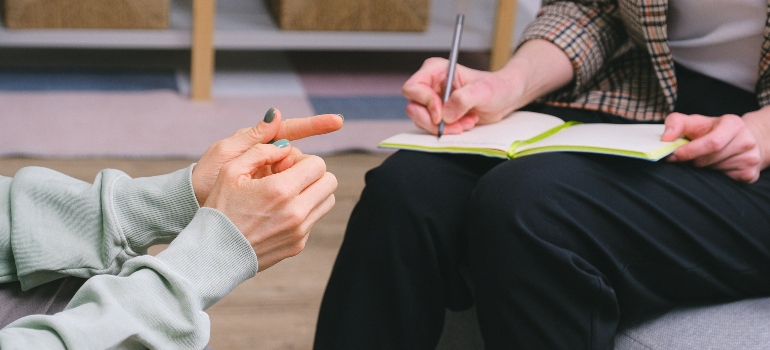 person taking notes about group vs individual treatment for substance use disorders