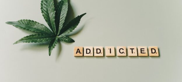 Addicted written with wooden letters as a featured image of a post about the differences between physical and psychological addiction