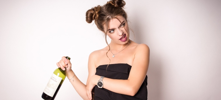 Woman holding a bottle of drink after combining alcohol with other drugs