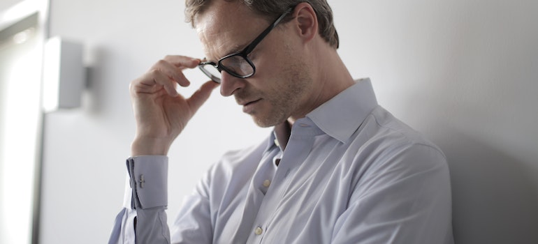 A man holding his glasses