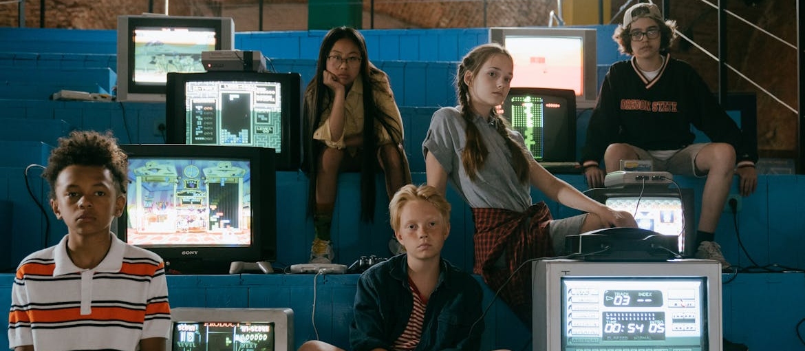 Pre-teens posing next to television screens representing how media and television influence drug use.