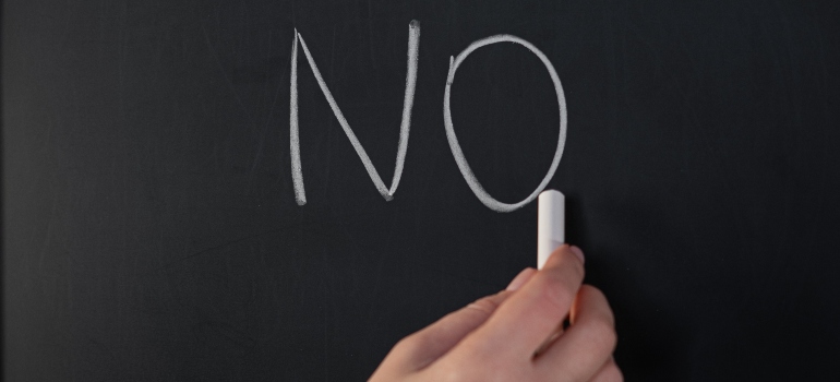 person writing "No" on a blackboard, symbolizing what to say when someone asks why you're not drinking
