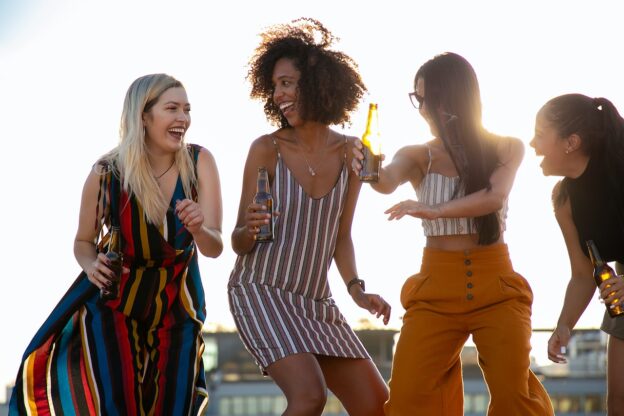 Four woman dancing while combining alcohol with other drugs