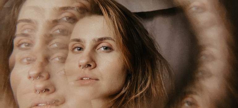 a person experiencing hallucination as if she is seeing multiple faces of herself