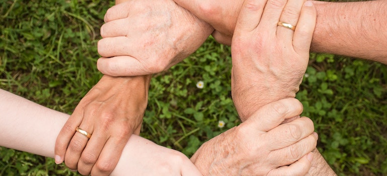 people holding hands and supporting each other