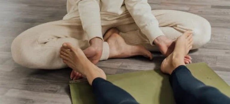 A close-up of a person massaging the feet of another.