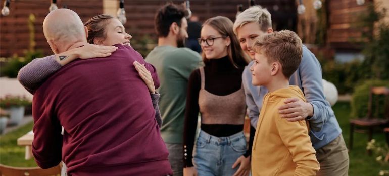 A group of people hugging during a gathering outdoors.