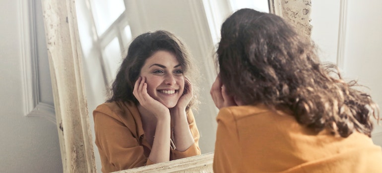 Woman looking at herself in the mirror showing the importance of mindfulness meditation during rehab in Marietta OH