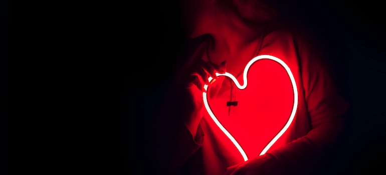 Person holding a neon heart