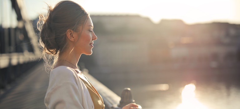 A happy woman standing on a brigde