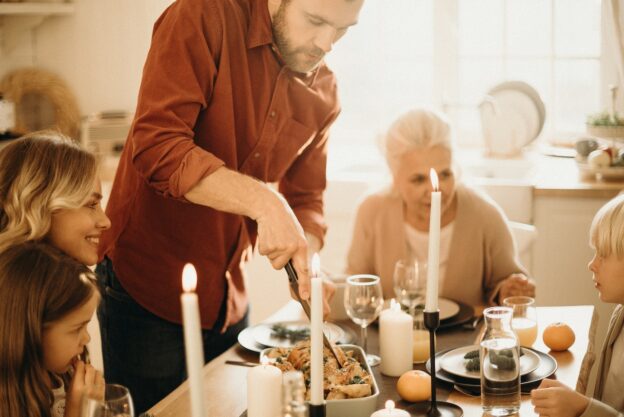 A family at dinner and a man lighting candles showing what do do if drug or alcohol abuse runs in your family