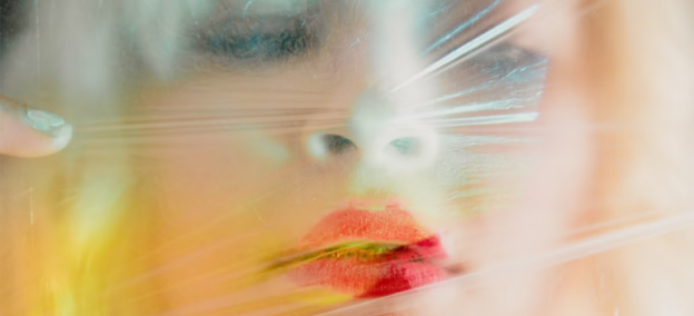 A close-up of a woman’s face wrapped in plastic, symbolizing the addiction stigma in West Virginia.