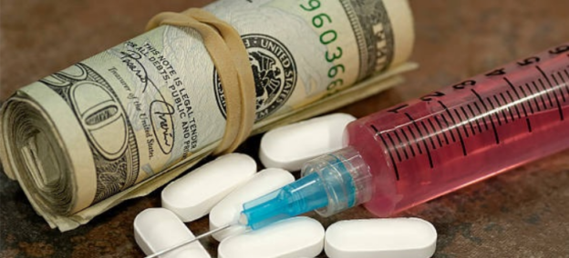 A syringe and pills next to a stack of dollar bills, symbolizing the opioid epidemic in West Virginia.