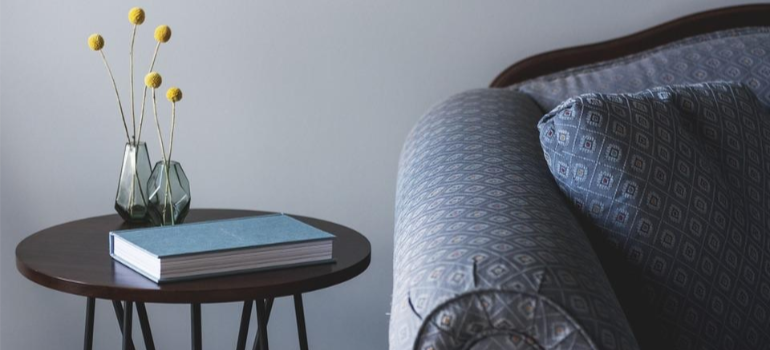 A book on a bedside table by a sofa.