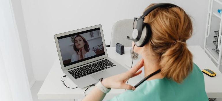 A medical professional during an online appointment with a patient, illustrating technology-assisted interventions for substance abuse.