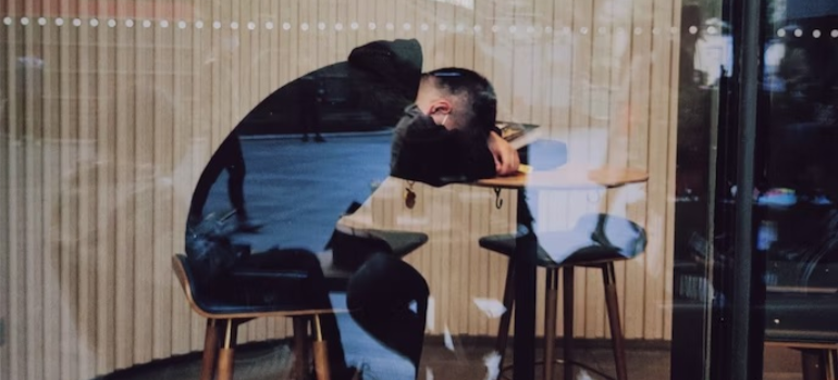 A close-up of an employee sleeping on a desk, illustrating the impact of addiction on West Virginia's economy through loss of productivity.