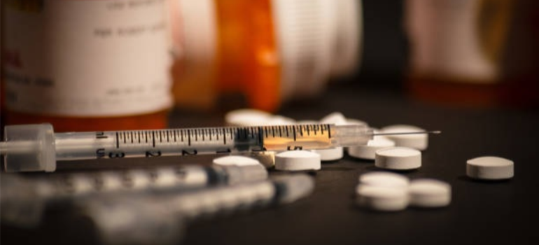 A syringe and pills, symbolizing the opioid epidemic in West Virginia.