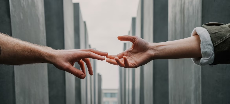 A close-up of two people touching hands.
