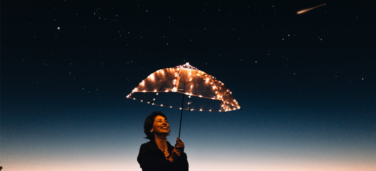 A woman holding a lit umbrella, illustrating how there is hope for combating drug addiction and homelessness in WV.