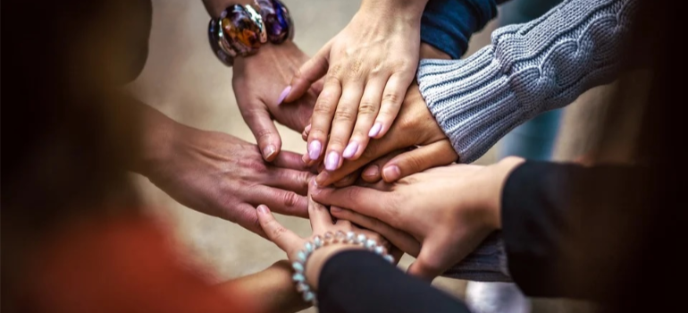 A close-up of people joining hands in solidarity.