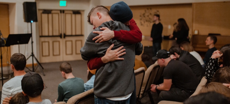 Two people hugging during addiction recovery group therapy