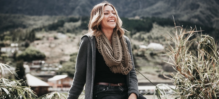 Happy woman smiling in the nature after undergoing harm reduction therapy.