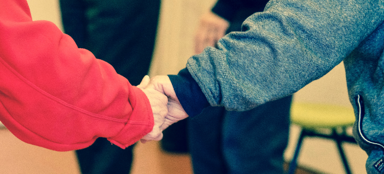 Two people in sweaters holding their hands together.