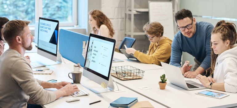 a welcoming office space with employees sitting at their computers and working together