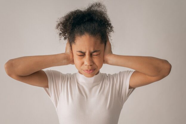 A woman covering her ears
