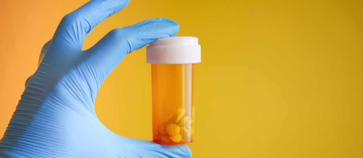 Doctor holding a bottle of prescription medication.