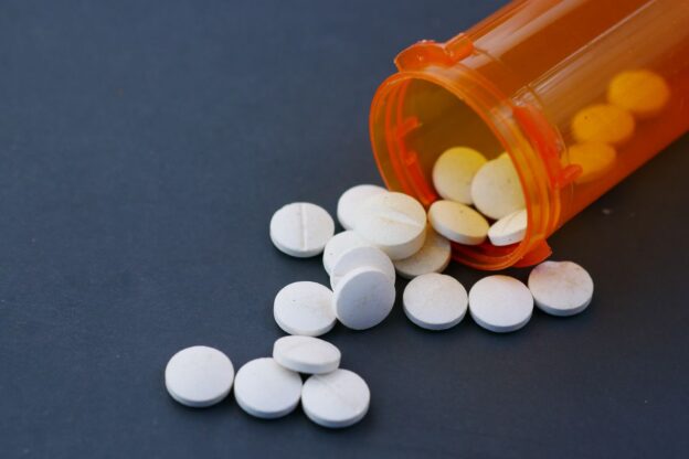 Pills spilling out of a prescription bottle.