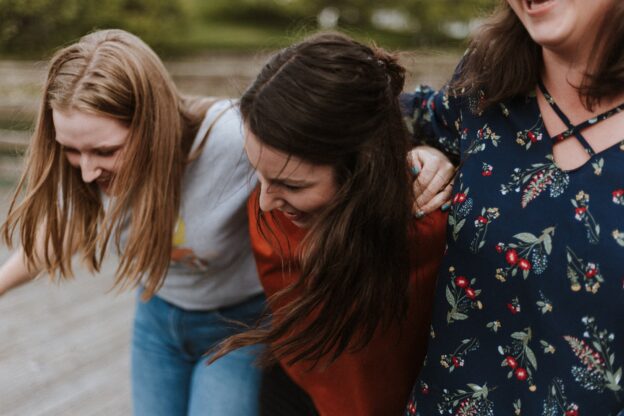 Three happy women hugging