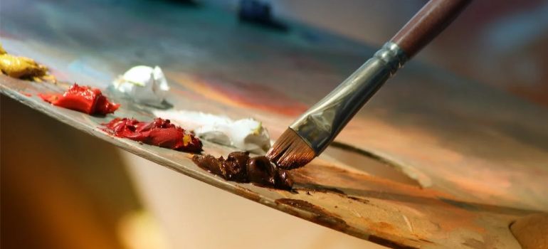 A close-up of a color pallet and a brush, illustrating how the effects and dangers of microdosing overlap with artistic expression.