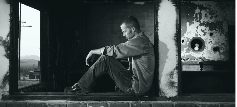 A black-and-white photo of a depressed man.
