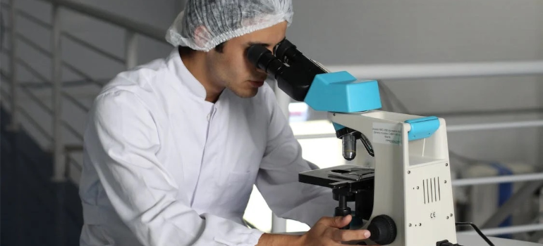 A close-up of a chemist at work, illustrating how the effects and dangers of microdosing require further research.